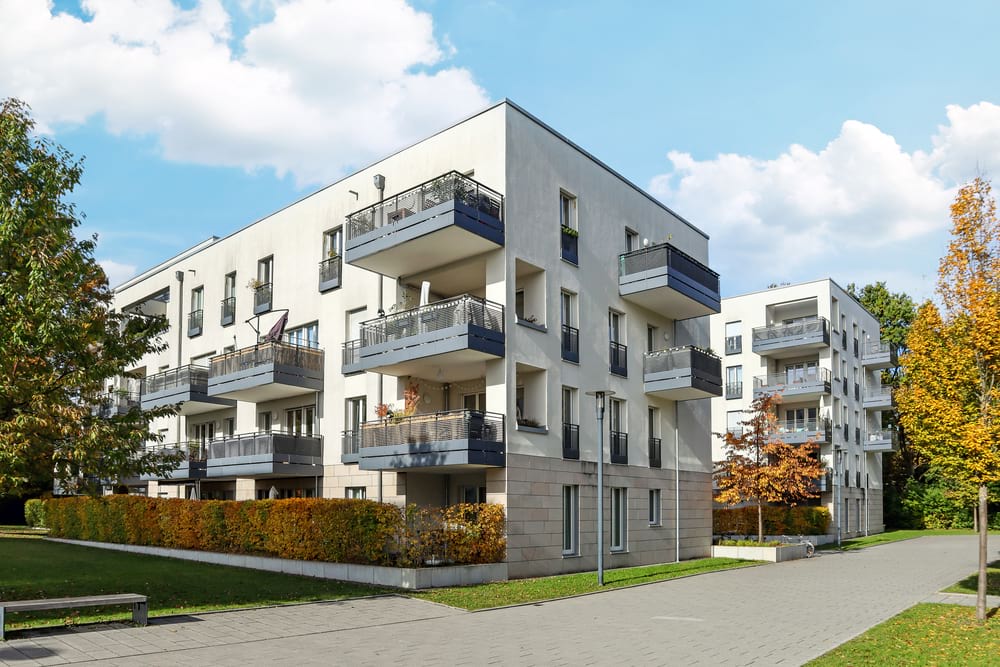 photo of two white blocks of flats that are three storeys high each